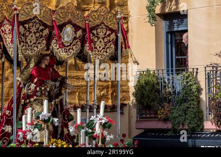 Ein Mann schaut von seinem Balkon auf einen Paso des Cofradía del Cristo del Gran Poder in Leon während einer Semana Santa Prozession, Spanien Stockfoto