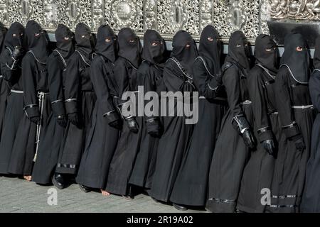 Mitglieder des Cofradía del Cristo del Gran Poder tragen während einer Semana-Santa-Prozession in Leon, Spanien, einen Paso Stockfoto