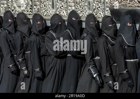 Mitglieder des Cofradía del Cristo del Gran Poder tragen während einer Semana-Santa-Prozession in Leon, Spanien, einen Paso Stockfoto