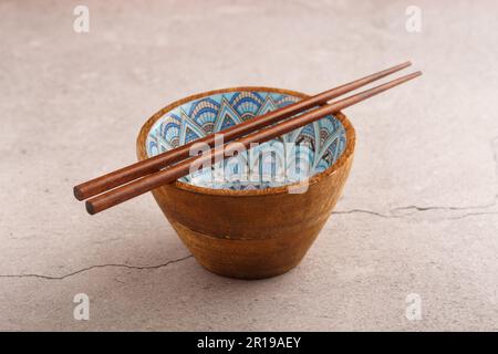 Bambusstäbchen auf asiatischer Holzschüssel. Speicherplatz kopieren. Schließen Stockfoto