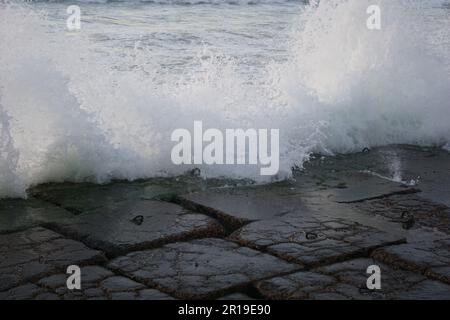 Mediterrane Wellen schlagen auf die Steine in Alexandria, Ägypten Stockfoto