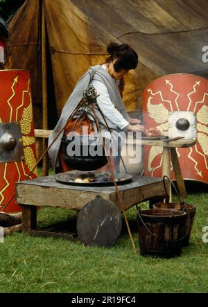 Zubereitung und Kochen von Fleisch in einem Kessel über einem Holzfeuer während einer Ausstellung der Ermine Street Guard im Loggerheads Country Park, North Wales, Großbritannien Stockfoto