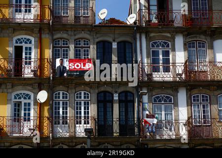 Verkaufsschild auf dem Balkon des historischen Apartmentgebäudes am Ufer des Viertels Ribeira, Porto/Porto, Portugal Stockfoto