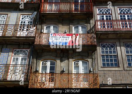 Verkaufsschild auf dem Balkon des historischen Apartmentgebäudes am Ufer des Viertels Ribeira, Porto/Porto, Portugal Stockfoto