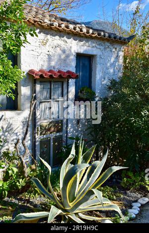 Weißes Steinhaus mit blauen Fensterläden Stockfoto