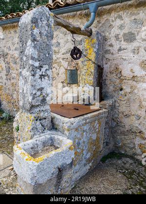 Altes Brunnen mit Eimer und Trog im Santuari de la Mare de Deu del Refugi im Castell d'Alaro Tramuntana Mallorca Stockfoto