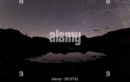 Panoramablick auf den Nachthimmel über Blea Tarn im englischen Lake District Stockfoto