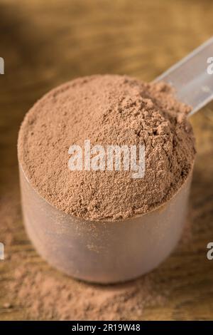 Organisches Schokoladen-Whey-Protein-Pulver in einem Löffel Stockfoto