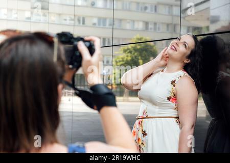 Photographers Day, professioneller Fotograf, der im Park Fotos oder Fotos im Freien macht. Fotografin mit einer großen professionellen Kamera Stockfoto
