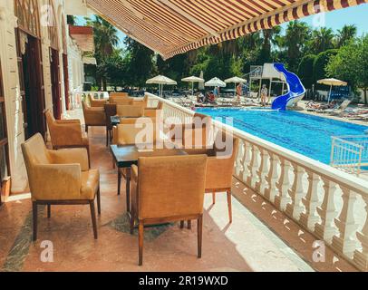 Flur in einem teuren Hotel im Urlaub. In der Nähe des Restaurants für den Empfang des Gäste-Swimmingpools mit Sonnenliegen. Im Esszimmer weicher Stuhl Stockfoto