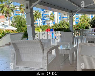 Weiße Tische und Stühle in einem Straßencafé, Freiluftrestaurant in einem warmen tropischen Land, Resort. Stockfoto