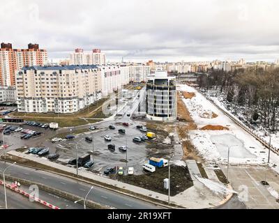 Der Blick aus dem Fenster von der Höhe der Stadtautobahn, die Häuser und Parkplätze im Winter. Panorama der Stadt. Stockfoto