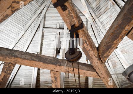 Die Textur der alten Holzbalken, Holzlagen und Decken, Lasthebevorrichtung, Räder, Hebezeuge unter der Decke. Das Hinterland Stockfoto