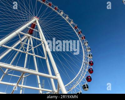 Vergnügungspark. riesenrad aus weißem Metall. Ein riesiges Rad mit Ständen für Touristen in Weiß und Rot. Karussellfahrt. Stockfoto