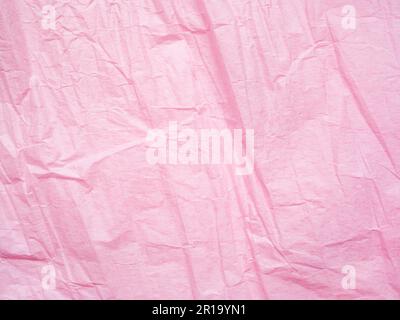 Rosafarbener Hintergrund mit zerknitterter Papierstruktur. Makroaufnahme des Geschenkpapiers. Gerillter Blatthintergrund. Texturierter Effekt der Seite. Abstraktes Muster, rosa Hintergrund Stockfoto