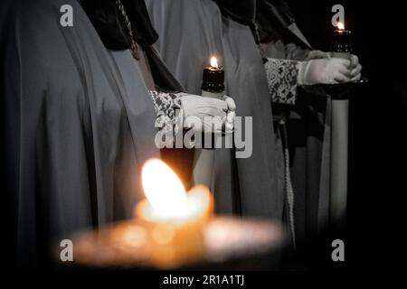 Detail der Mitglieder der Bruderschaft der Strafanstalt der Heiligen Passion Christi, die während der Semana Santa in Valladolid, Spanien, Kerzen hielten Stockfoto