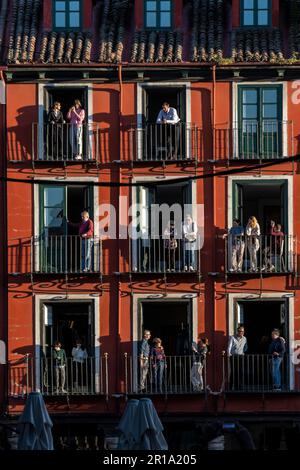 Zuschauer sehen Semana Santa Prozessionen von ihrem Balkon auf der Plaza Mayor, Valladolid, Spanien Stockfoto