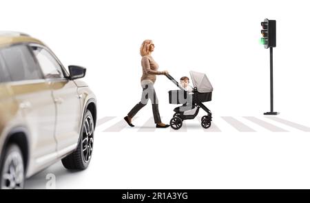 Profilaufnahme über die gesamte Länge einer erwachsenen Frau, die eine Straße überquert, mit einem Baby in einem Kinderwagen isoliert auf weißem Hintergrund Stockfoto