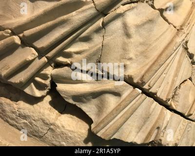 Textur einer Wand aus sandigem Gestein aus einem gelben, brüchigen, alten, faulen Gestein mit Scherben, Löchern und Sandschichten. Der Hintergrund. Stockfoto