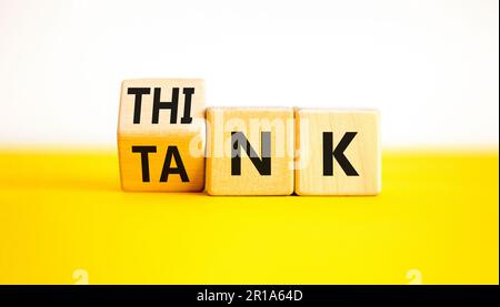 Denkfabriksymbol. Ein Geschäftsmann dreht Holzwürfel um und ändert das Wort „Tank“, um zu denken, oder umgekehrt. Schöner gelber Tisch, weißer Hintergrund, Kopie Spac Stockfoto