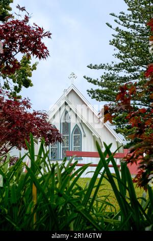 Kerikeri neuseeland - 3 2011. März; Alt - Historische kleine, weiße, holzige anglikanische Kirche St. James wird von Bäumen in vertikaler Zusammensetzung eingerahmt. Stockfoto