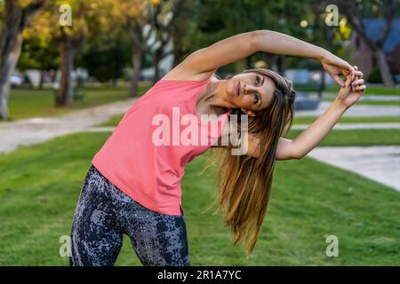 Attraktive und gesunde junge Frau, die Stretching-Übungen im Freien macht Stockfoto