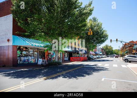 WAYNESVILLE, NC, USA-4. MAI 2023: Main Street, farbenfrohe Geschäftsfrau, Sommerlaub. Stockfoto