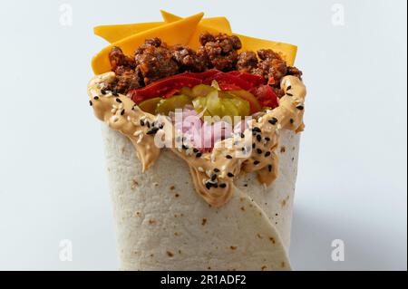 Hähnchen-Schawarma, verpackt in Pita-Brot und frischem, saftigen Salat und Sauce auf Holzbretterhintergrund Stockfoto