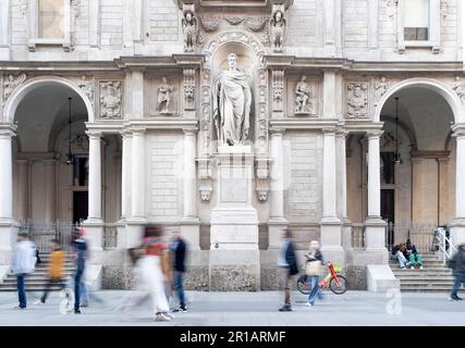 Giureconsulti-Palast aus dem 16. Jahrhundert, auf der piazza Mercanti (Handelsplatz), mit der steinigen Sankt Ambrose und verschwommen nicht wiedererkennbaren Menschen und Touristen. Stockfoto