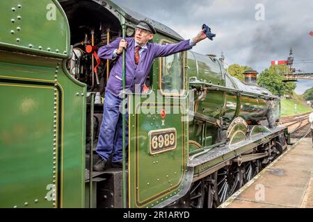 Der Fahrer von BR 'Hall' 4-6-0 Nr. 6989 'Wightwick Hall' bekommt den nächsten Zug am Bahnhof Horsted Keynes der Bluebell Railway, East Sussex Stockfoto