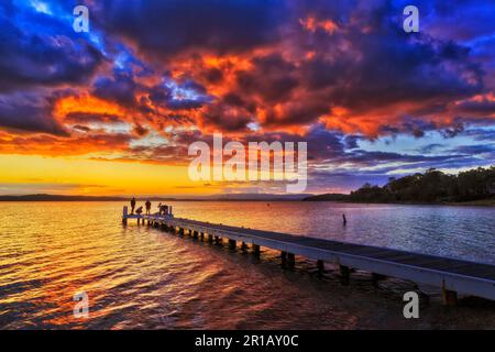 Langer Holzsteg vor Cams Wharf Murrays Beach am Lake Macquarie in Australien bei malerischem Sonnenuntergang. Stockfoto