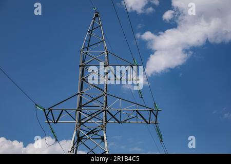 Hochspannungsturm unter blauem bewölktem Himmel Stockfoto