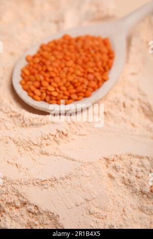 Löffel mit Linsenkörnern auf Mehl, Nahaufnahme Stockfoto