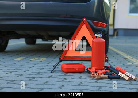 Warndreieck und Sicherheitsausrüstung in der Nähe des Fahrzeugs, Platz für Text Stockfoto