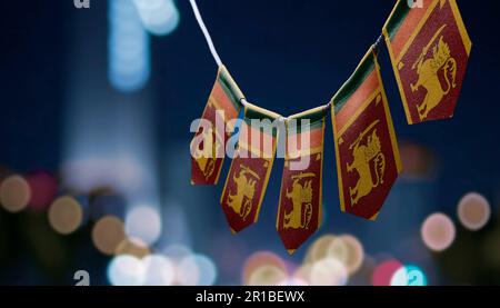 Eine Girlande Sri Lankas Nationalflaggen auf abstraktem, verschwommenem Hintergrund. Stockfoto