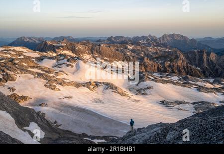 Blick auf felsiges Plateau mit Schnee und Gletscher bei Sonnenaufgang, auf der Hochkoenig, Uebergossene Alm, Blick auf Steinernes Meer und Watzmann, Berchtesgaden Stockfoto
