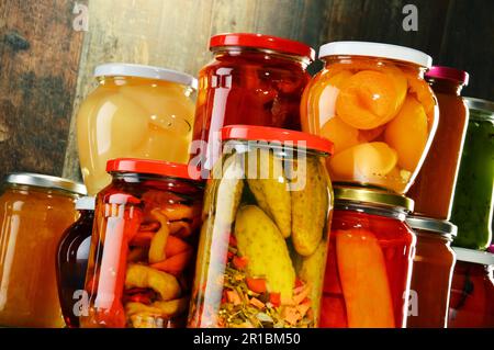 Gläser mit eingelegtem Gemüse, fruchtigen Kompotte und Marmeladen im Keller. Konservierte Lebensmittel Stockfoto