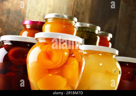 Gläser mit eingelegtem Gemüse, fruchtigen Kompotte und Marmeladen im Keller. Konservierte Lebensmittel Stockfoto