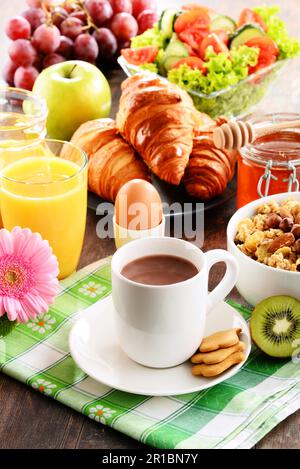 Das Frühstück, bestehend aus Obst, Orangensaft, Kaffee, Honig, Brot und Ei. Ausgewogene Ernährung Stockfoto