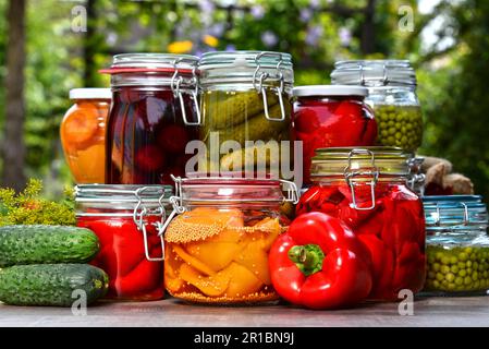 Eingelegte Gemüse- und Obstgläser im Garten. Mariniertes Essen Stockfoto