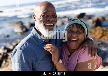 Portrait eines glücklichen, hochrangigen afroamerikanischen Paares, das sich am Meer umarmt Stockfoto