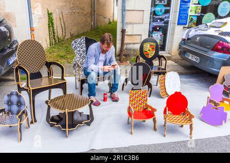 Händler mit lasergeschnittenen, lackierten Holzstühlen und -Sitzen auf dem Mai-Sondermarkt – Martizay, Indre (36), Frankreich. Stockfoto