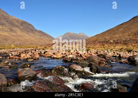 Blick auf den Pfad zwischen Liathach und Ben Alligin mit Beinn Eighe in der Ferne und Bach im Vordergrund. Torridon in Schottland. Stockfoto