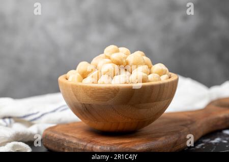 Macadamianüsse. Macadamianüsse in Holzschüssel. Superfood. Vegetarisches Speisenkonzept. Gesunde Snacks Stockfoto