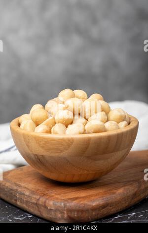 Macadamianüsse. Macadamianüsse in Holzschüssel. Superfood. Vegetarisches Speisenkonzept. Gesunde Snacks. Schließen Stockfoto