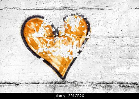 Orangefarbenes, abstraktes Herzsymbol, schmutzige Wandhintergründe, Metapher zum urbanen und romantischen valentinstag, Grunge-Stil. Stockfoto