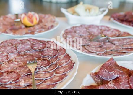 Gepökeltes Fleisch auf Tellern, bereit für eine Veranstaltung oder Party. Vorspeise. Stockfoto