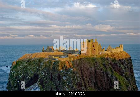 Das isolierte Dunnottar Castle in der Nähe von Stonehaven an der Ostküste Schottlands unter der untergehenden Wintersonne. Stockfoto