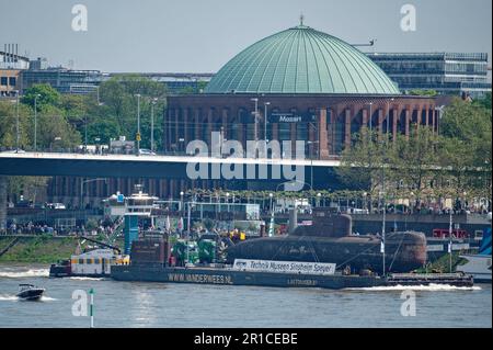 Düsseldorf, Deutschland. 13. Mai 2023. Das stillgelegte U-Boot U17 wird auf einem Lastträger auf dem Rhein durch die Düsseldorfer Innenstadt transportiert. Das U-Boot ist auf dem Weg zum Technik-Museum Speyer. Kredit: Henning Kaiser/dpa/Alamy Live News Stockfoto