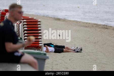 Palma, Spanien. 11. Mai 2023. Zwei Leute liegen am Strand von Arenal. Die Playa de Palma am Ballermann auf Mallorca hat die „blaue Flagge“ und damit den Status als Strand von ausgezeichneter Qualität verloren. (Zu dpa 'Ballermann Beach verliert 'blaue Flagge' für exzellente Qualität') Kredit: Clara Margais/dpa/Alamy Live News Stockfoto